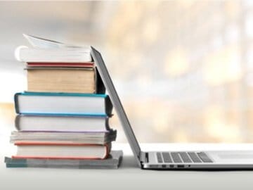 A stack of books and a laptop