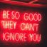 A red neon sign saying the phrase 'be so good they can't ignore you'.